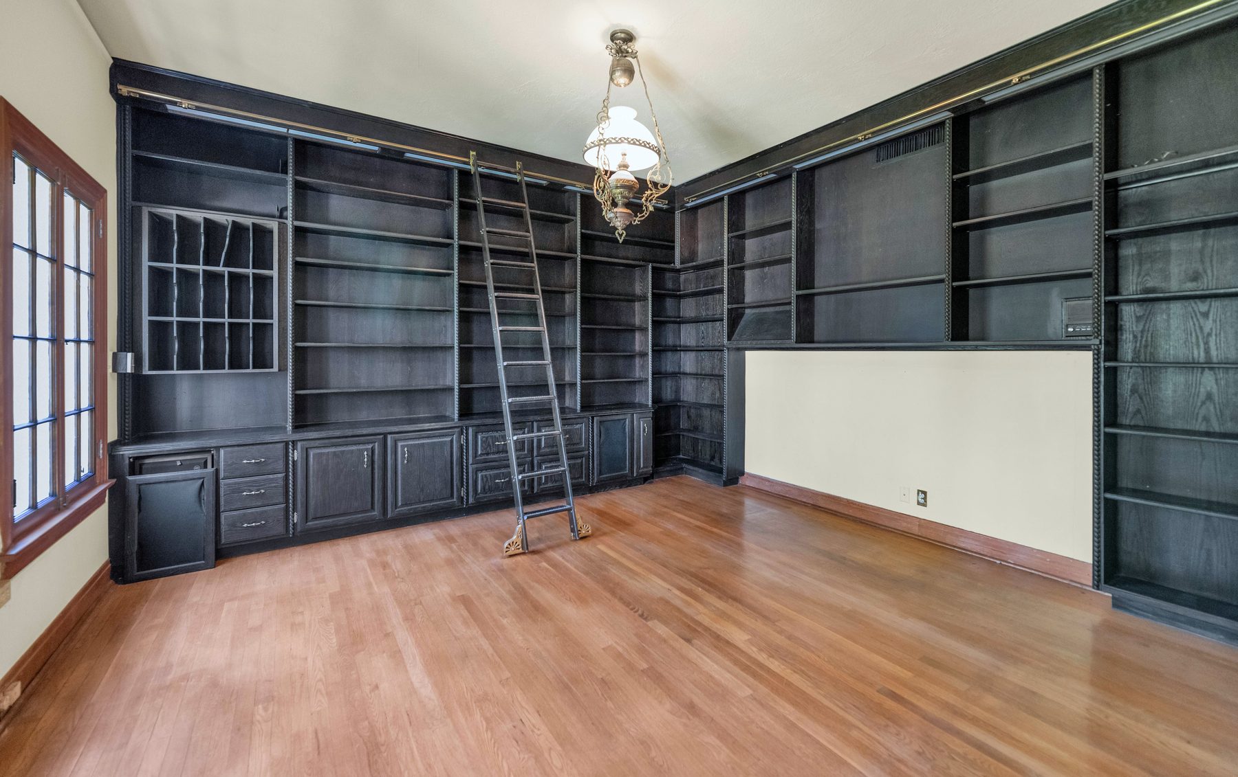 Library with rolling ladder and wood paneling